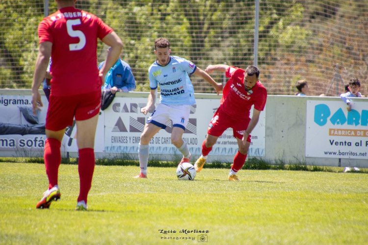 Miguel Mallada conduce el balón ante dos rivales.